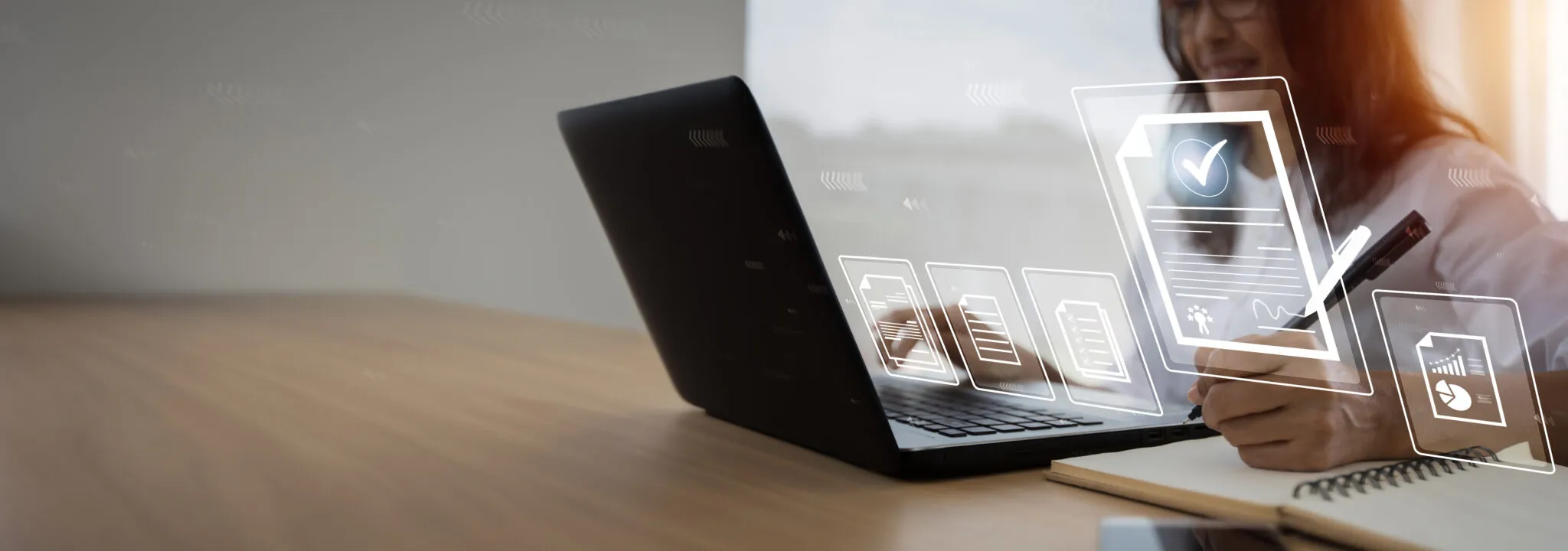 A person typing on a laptop and taking notes. There are illustrations of icons that appear on the screen to show what type of work they are doing.